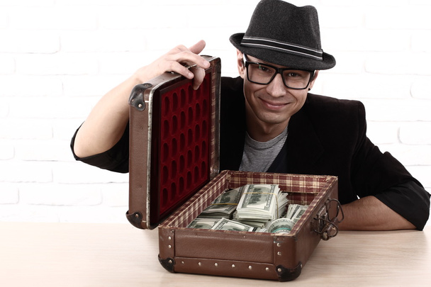 Емоційний чоловік в окулярах тримає пачки грошей
 - Фото, зображення