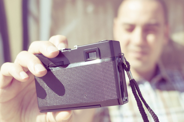 jonge man een selfie met een oude filmcamera, gefilterd - Foto, afbeelding