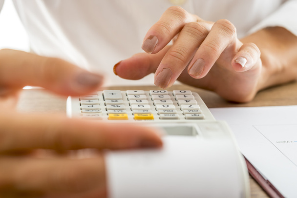 Banqueiro feminino calculando despesas e renda usando a adição de machi
 - Foto, Imagem