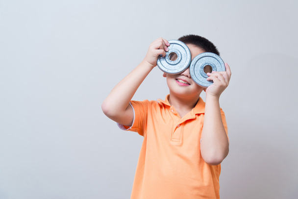 Азиатский мальчик шутки жест носить поддельные очки, сделанные из железа дум
 - Фото, изображение