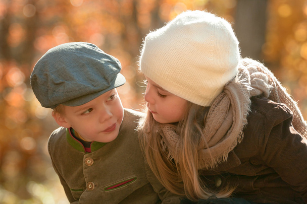 brother and sister dressed up warm looking at each other outdoors - Photo, Image