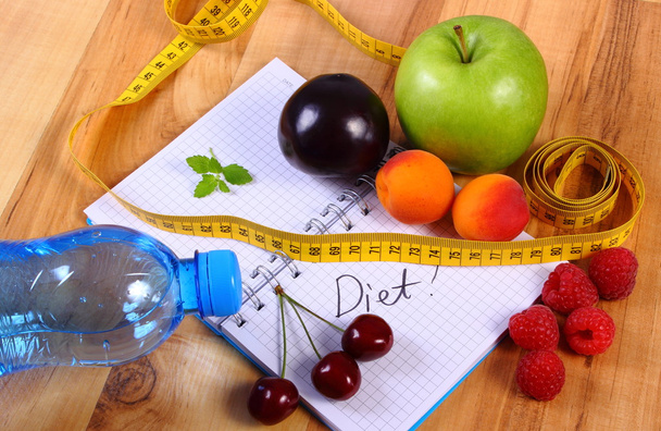 Frutas y centímetros con cuaderno, adelgazamiento y alimentación saludable
 - Foto, imagen