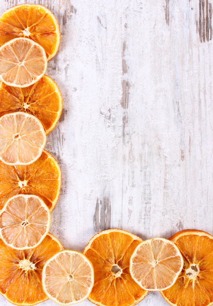 Slices of dried lemon and orange on old wooden background, copy space for text - Foto, afbeelding