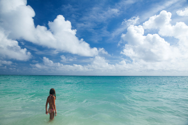 Dziewczyna cieszy się letni dzień na tropikalnej plaży. - Zdjęcie, obraz