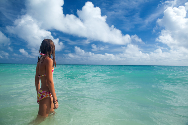 Κορίτσι απολαμβάνει καλοκαιρινή μέρα στην τροπική παραλία. - Φωτογραφία, εικόνα