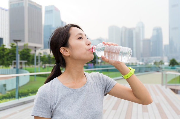 Frau trinkt Wasser nach dem Laufen - Foto, Bild