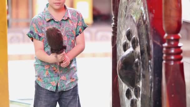 Pieni aasialainen poika otsatukka suuri Antiikki Thai Gong (Bell) / Nämä Gongit olivat perinteisesti löydetty ulkopuolella buddhalainen temppelit Thaimaassa
. - Materiaali, video