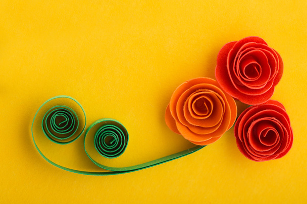Бумажные цветы розы, сделанные с техникой перьев на желтом backgr
 - Фото, изображение
