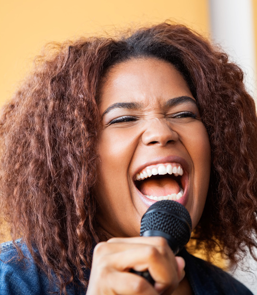 Mikrofon tutarken genç kadın şarkı heyecanlı - Fotoğraf, Görsel