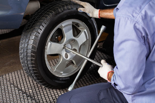 Mechanic Fixing Car Tire With Rim Wrench - Photo, image
