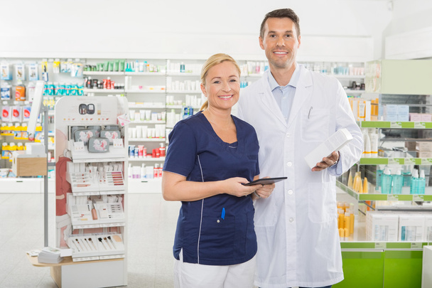 Asistente sonriente que usa tableta digital mientras sostiene farmacia
 - Foto, Imagen