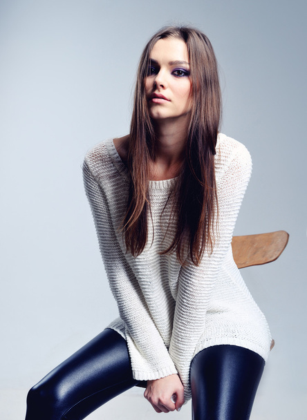 Pretty brunette covering herself in a warm sweater - Фото, изображение
