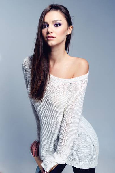 Pretty brunette covering herself in a warm sweater - Photo, Image