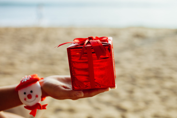 christmas gift in red box on the beach - Photo, Image