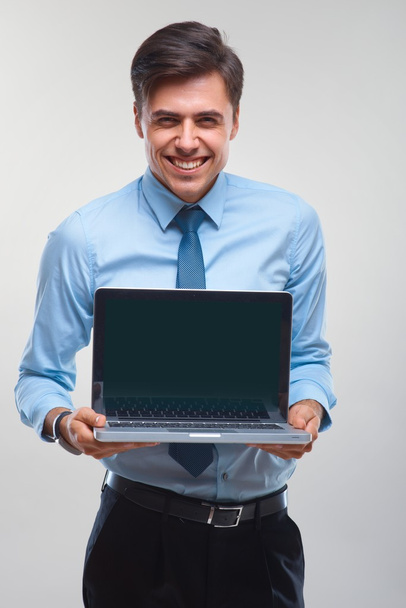 Business man holding a laptop against a white background - Foto, imagen
