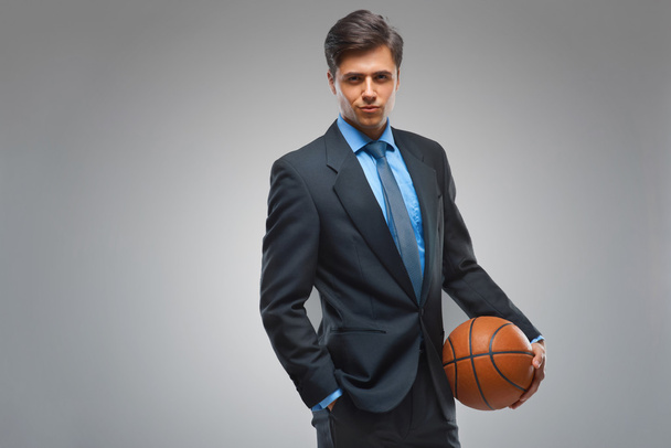 Businessman with ball against gray background - Zdjęcie, obraz