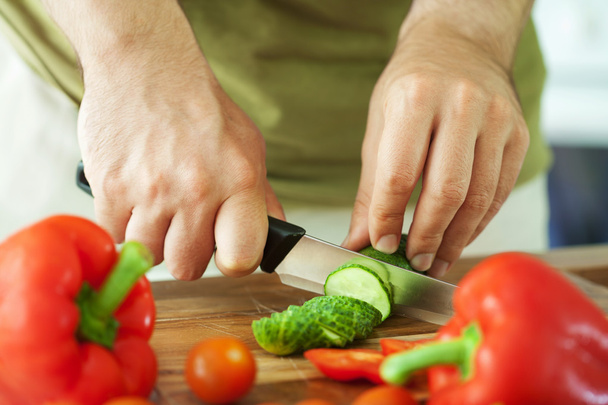 Hombre cortando verduras para ensalada - Foto, imagen