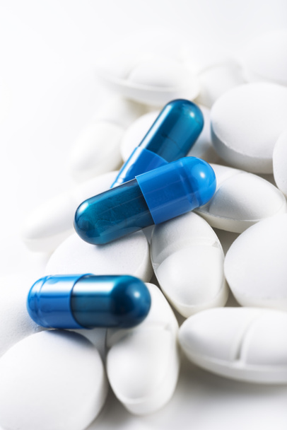 modré pilulky a bílé tablety - Fotografie, Obrázek