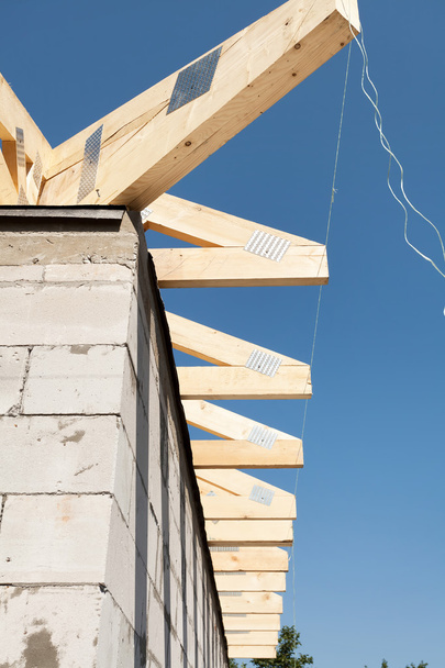 Instalación de vigas de madera, vigas de techo en la construcción del techo. Nueva casa hecha con bloques de hormigón aireado en autoclave
 - Foto, Imagen