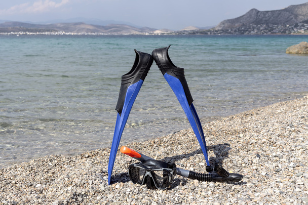 Плавники, маска и подводное плавание на каменном пляже
 - Фото, изображение