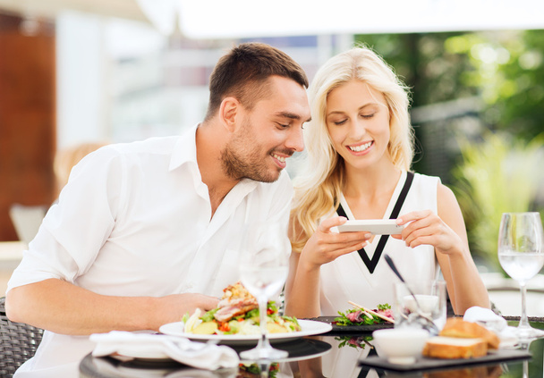 happy couple with smatphone photographing food - Фото, зображення