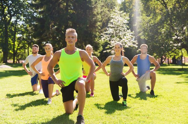 group of friends or sportsmen exercising outdoors - Foto, Bild