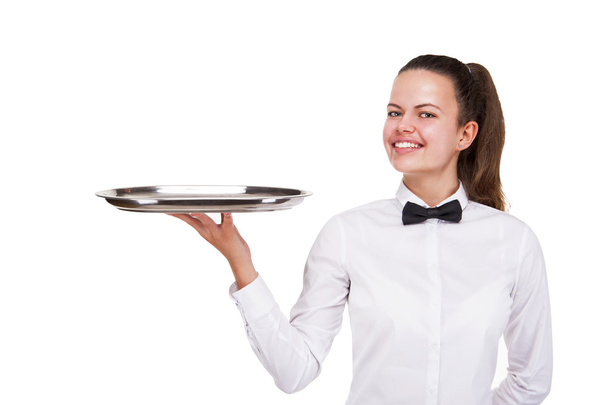 Νεαρή γυναίκα με τη στολή σερβιτόρος κρατώντας δίσκο απομονωθεί πάνω από το λευκό β - Φωτογραφία, εικόνα
