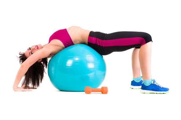 Young smiling woman makes exercise with fitball, full length portrait isolated over white - Fotó, kép