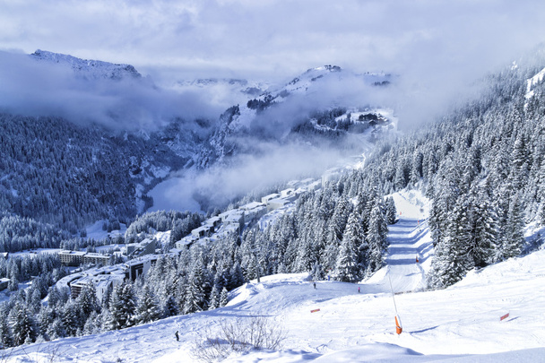 Station de ski française Flaine dans le Grand Massif des Alpes avec chalets, immeubles, pinèdes et pistes, par une journée d'hiver brumeuse
 - Photo, image