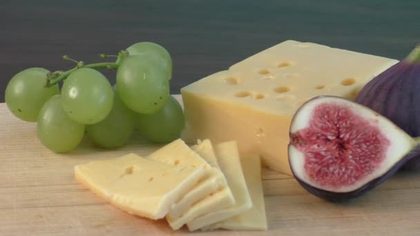Sárga sajt és a friss füge a fa vágódeszka - Felvétel, videó
