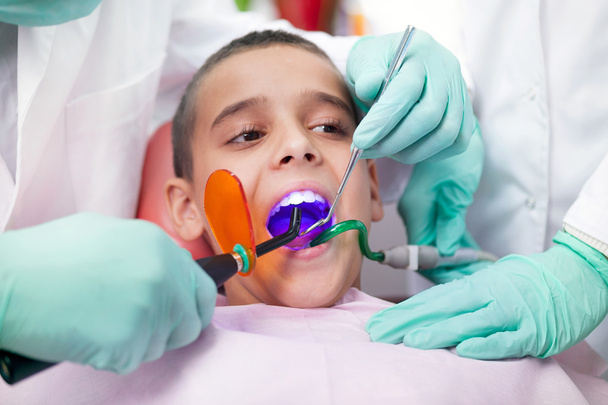 Κοντινό πλάνο του αγοριού που έχει τα δόντια του εξέτασε από έναν οδοντίατρο - Φωτογραφία, εικόνα