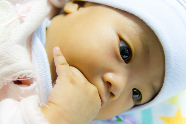 Aasialainen naaras vauva imee sormiaan
 - Valokuva, kuva