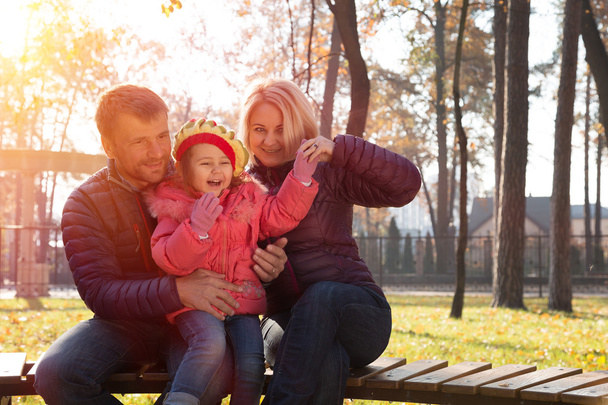 Счастливая молодая семья вместе в парке смеется
 - Фото, изображение