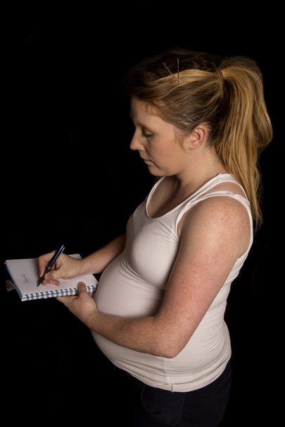妊娠中の女性は赤ちゃんのリストを記述 - 写真・画像