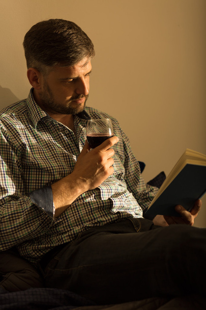 Lorn man relaxing with book - Фото, изображение