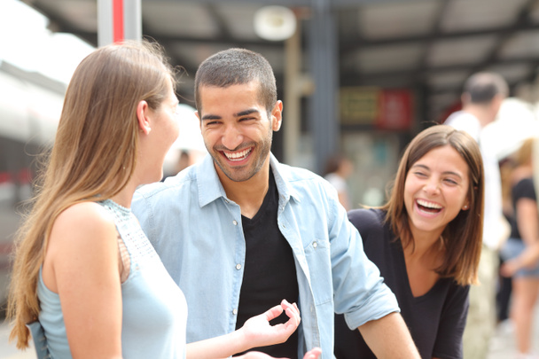 Three friends talking and laughing in a train station - Foto, imagen