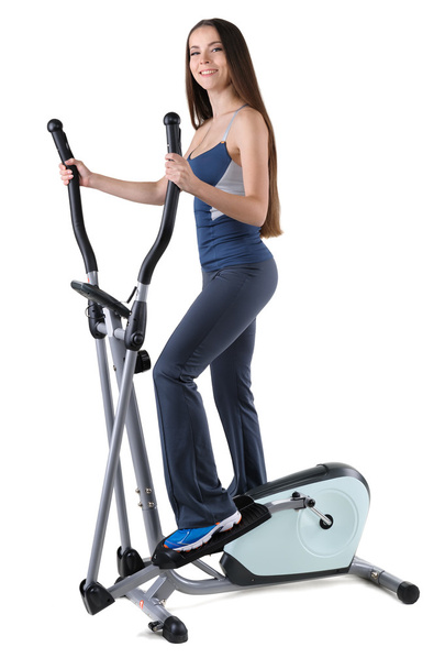 young woman doing exercises on elliptical trainer - Zdjęcie, obraz