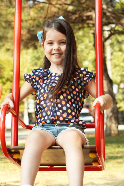 Happy little girl riding swings - Fotoğraf, Görsel