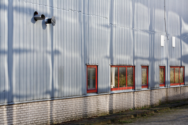 Grey wall with red window frames - Фото, изображение