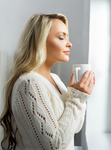Kobieta pije kawę z zamkniętymi oczami - Zdjęcie, obraz