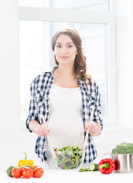pregnant woman mixing salad - Foto, Imagem