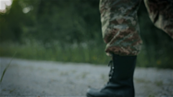 certo homem militar andar na estrada arenosa
 - Filmagem, Vídeo