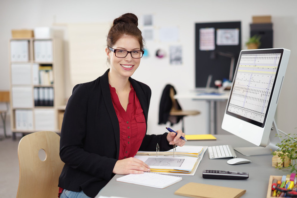Smiling businesswoman working in an office - Foto, Bild
