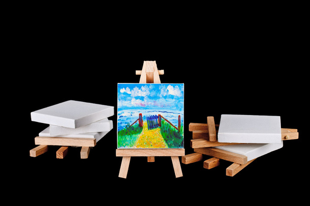 Artists easels stacked on a black background - Photo, Image