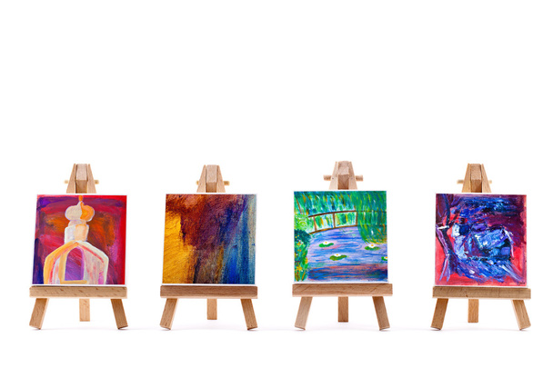 Four paintings on easels isolated on white - Photo, Image