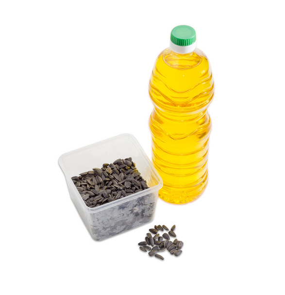 Sementes de girassol em bandeja de plástico e garrafa de óleo de girassol
 - Foto, Imagem
