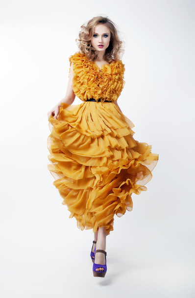 Lovely woman blonde fashion model in yellow dress posing - Foto, afbeelding