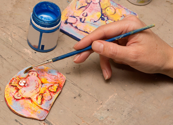 kunstenaar hand met penseel in het proces schilderij klei panelen - Foto, afbeelding