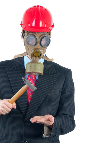 Business man with gas mask and helmet striking with hammer - Фото, изображение