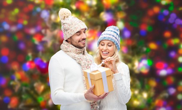 smiling couple in winter clothes with gift box - Foto, Imagem